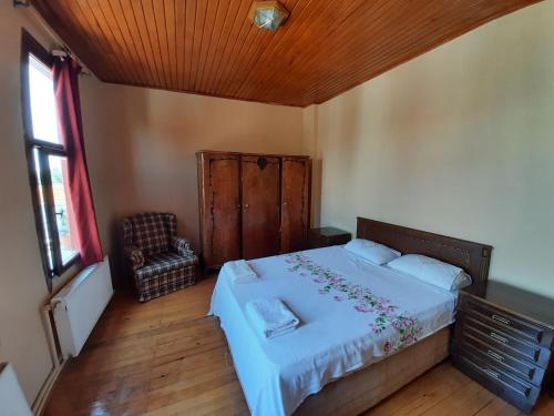 1 dormitorio pequeño con 1 cama y 1 silla en Manzaraada Merkez en Heybeliada