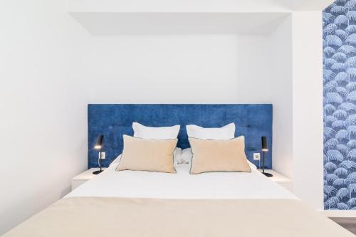 a bedroom with a white bed with a blue headboard at iloftmalaga Ricardo Soriano in Marbella