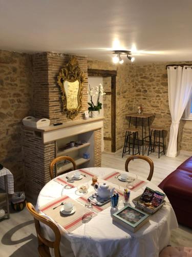 uma sala de estar com mesa e cadeiras e uma cozinha em Les Tilleuls em La Porcherie