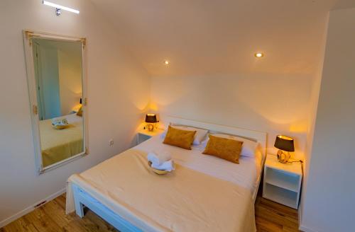 a bedroom with a white bed and a large mirror at Villa Mara in Drniš