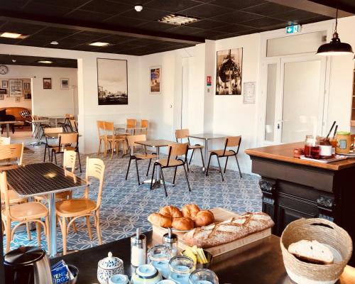 a room with tables and chairs and a cafeteria at LES BAIGNEURS in Saint-Gilles-Croix-de-Vie