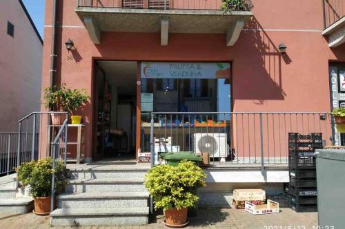 a pink building with stairs and plants in front of it at Holiday house by the lake in Arona