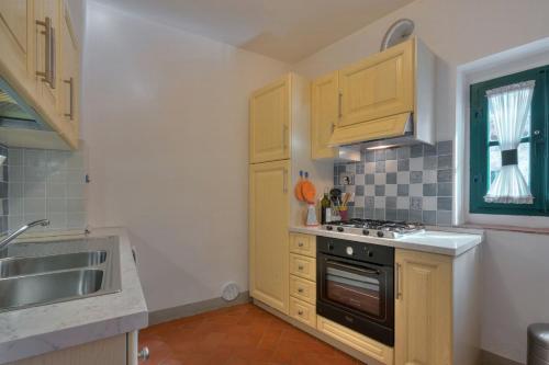 a kitchen with wooden cabinets and a stove top oven at Castello di Sarna in Chiusi della Verna