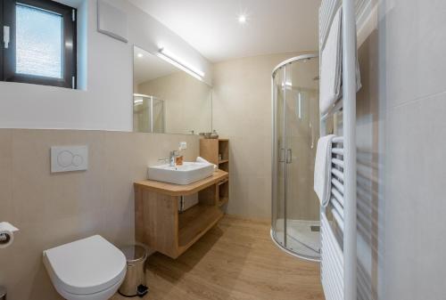 a bathroom with a toilet sink and a shower at Garni Hotel Am Meilenstein in Rablà