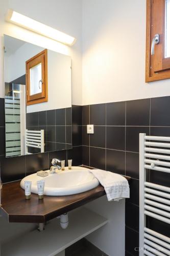 une salle de bain avec un lavabo et un miroir dans l'établissement Vacancéole - Le Domaine des Monédières, à Meyrignac-lʼÉglise