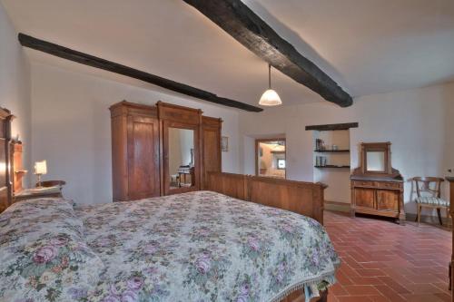 a bedroom with a bed with a floral bedspread at Castello di Sarna in Chiusi della Verna