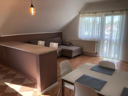 un soggiorno con tavolo, sedie e divano di Hanga Apartman a Tiszafüred