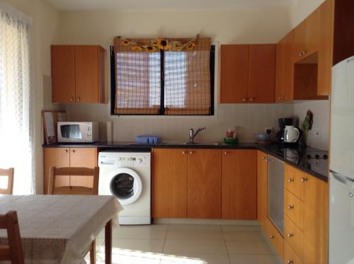 cocina con lavadora y lavadora en St. Lazaros Seaside Apartment, en Lárnaca