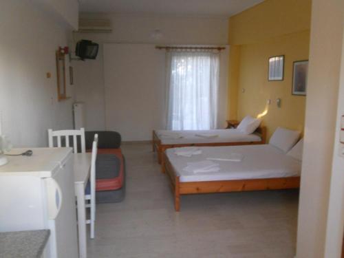 Habitación pequeña con 2 camas y cocina en Assimakis Hotel, en Finikounta