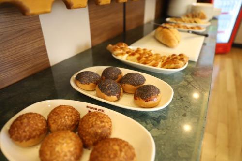 a table with plates of donuts and pastries on it at Buldum Otel in Ankara