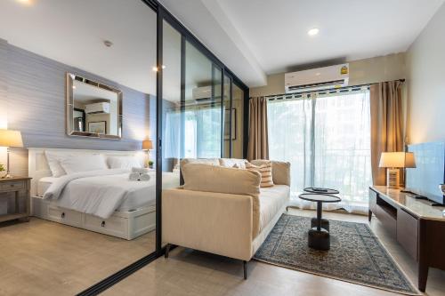 1 dormitorio con cama, silla y espejo en la Casita Hua Hin by J&P, en Hua Hin