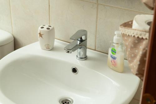 a bathroom sink with a toothbrush and a bottle of soap at Narkissos 'SUPERB' in Chania Town