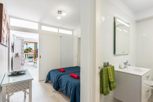 a bedroom with a bed and a sink in a room at Tenerife South Apartments in Playa de las Americas