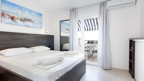 a bedroom with a large white bed with white pillows at Apartment Vegas in Novalja