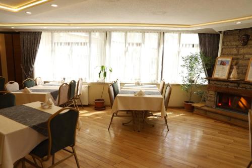a restaurant with tables and chairs and a fireplace at Buldum Otel in Ankara