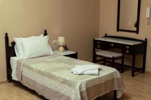 a bedroom with a bed with a dresser and a mirror at Narkissos 'SUPERB' in Chania Town