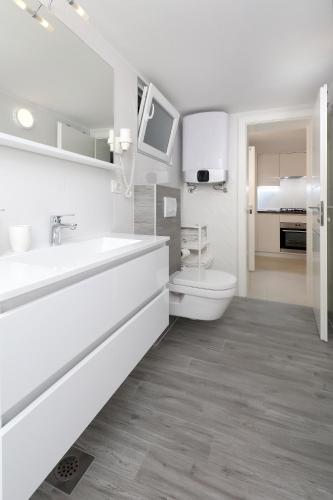 a white bathroom with a sink and a toilet at Apartment Vegas in Novalja