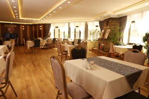 une salle à manger avec des tables et des chaises blanches dans l'établissement Buldum Otel, à Ankara