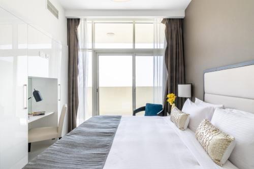 a bedroom with a large white bed with a window at The Smart Concierge - Damac 108 in Dubai