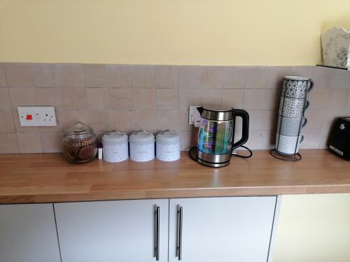 a kitchen counter with a coffee maker on top of it at Tynant House- Modern 3 bed house- City centre and FREE parking in Cardiff