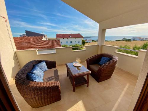 een balkon met rieten stoelen en een tafel met uitzicht bij Villa Cvita in Povljana