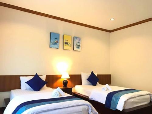 a hotel room with two beds with blue pillows at Papai Country Lodge SHA in Ban Mae Pong