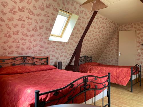een slaapkamer met 2 bedden en een raam bij Dday House in Saint-Laurent-sur-Mer