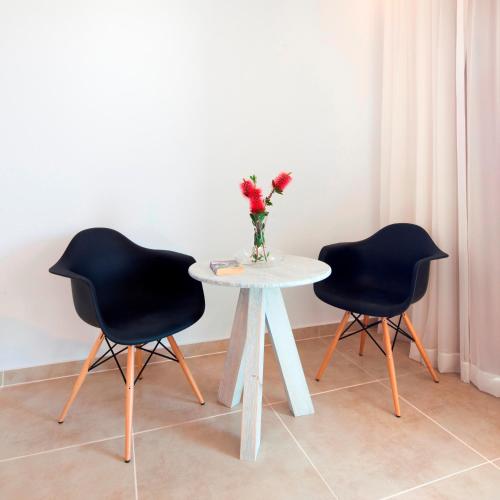 two chairs and a white table with a vase of flowers at Gold Lagoon Kosher Hotel - by Amphora Hotel & Suites in Paphos City