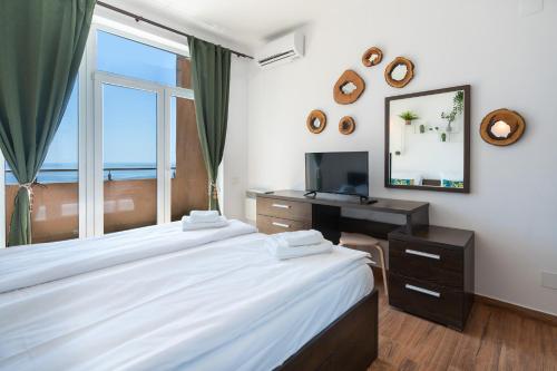 a bedroom with two beds and a desk and a mirror at Rezident Eforie Nord in Eforie Nord