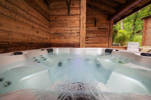 a jacuzzi tub in a wooden cabin at Chalet Hohneck 4 étoiles, vieux bois et pierre, SPA, sauna, borne de recharge in Stosswihr
