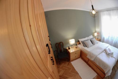a bedroom with a bed and a desk and a window at Apartment DobraYa Blue in Novi Sad