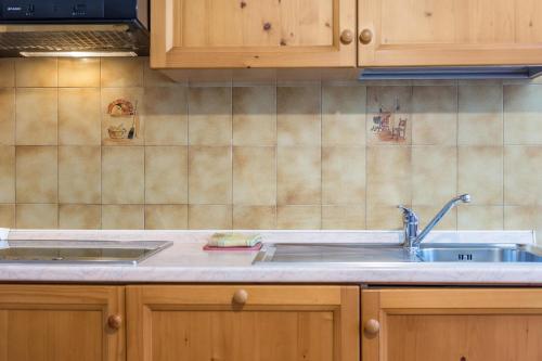 a kitchen with wooden cabinets and a sink at Casa Lorenz 2 in Canazei