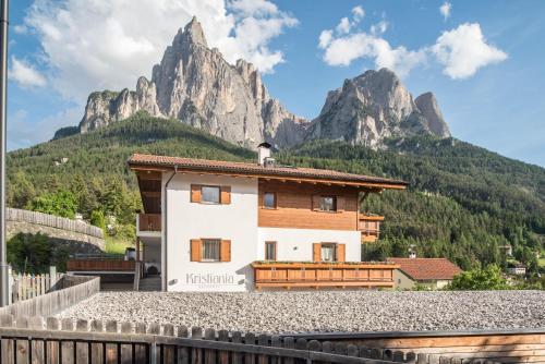 a house with a mountain in the background at Kristiania Apartement Typ A1 in Siusi