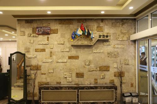 a stone wall with a fireplace in a lobby at Buldum Otel in Ankara