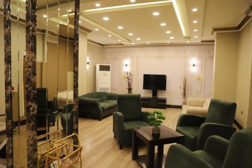 a living room with couches and a flat screen tv at Buldum Otel in Ankara