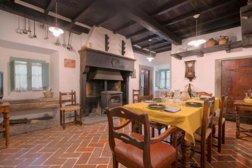 a dining room with a table and a fireplace at Castello di Sarna in Chiusi della Verna