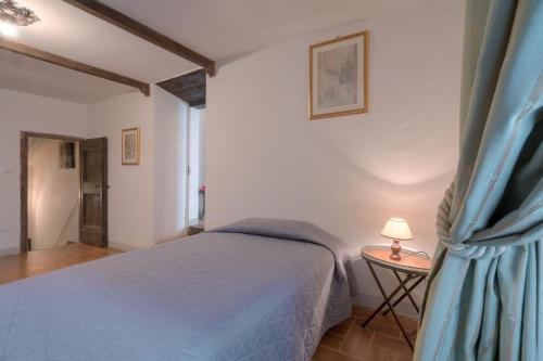 a bedroom with a bed and a table with a lamp at Castello di Sarna in Chiusi della Verna