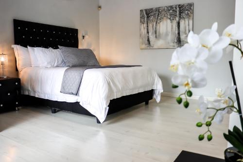 a bedroom with a bed with white sheets at Augusta Palms in Centurion