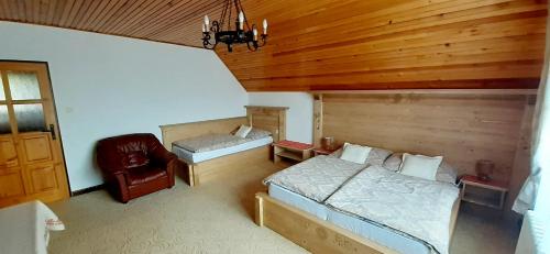 a bedroom with two beds and a chair at Apartmán Astra v Ždiari in Ždiar