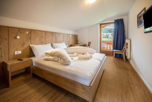 um quarto com uma cama grande e uma cabeceira em madeira em Residence Condor Apt Schlern em Maranza