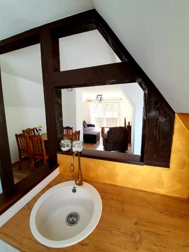 a bathroom with a sink and a living room at Penzión na Hálni in Nižná Boca