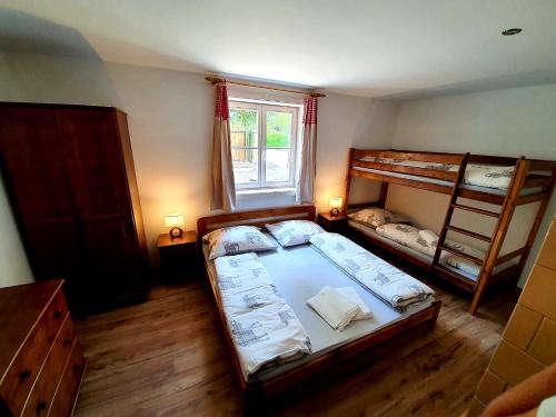 a bedroom with two bunk beds and a window at Penzión na Hálni in Nižná Boca
