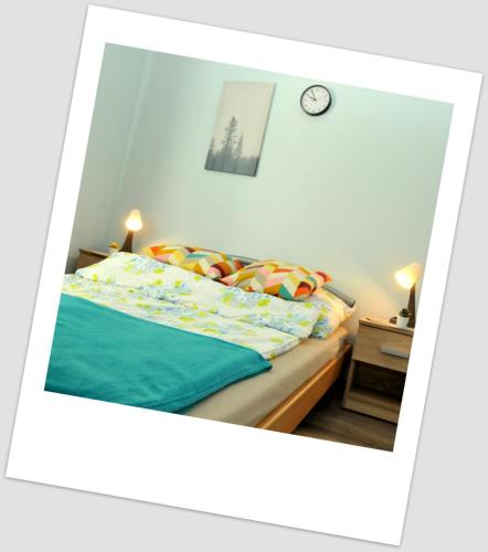 um quarto com uma cama e um relógio na parede em Apartament w Alei Fontann. em Szczecin