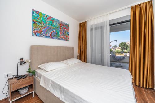 a bedroom with a large bed and a window at Accordion Apartment in Bar