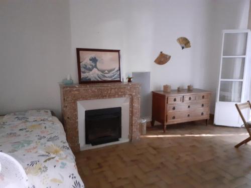 - une chambre avec une cheminée, un lit et une commode dans l'établissement SENTIMIR, à Saint-Génis