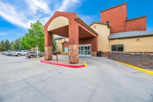 a building with a large arch in front of a parking lot at Sleep Inn Flagstaff in Flagstaff
