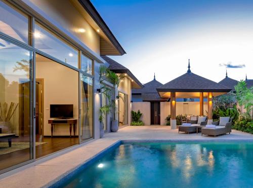 an indoor swimming pool in the backyard of a house at Splash Beach Resort Phuket, Family-Friendly Beachfront Water Park Resort in Mai Khao Beach