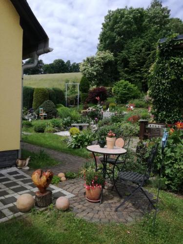 a patio with a table in a garden at Ferienwohnung Tuchscherer in Cranzahl