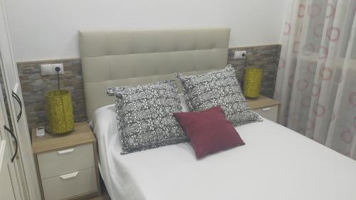 ein Schlafzimmer mit einem weißen Bett mit Kissen in der Unterkunft FINCA VILLA ZAAR HOMES in Puerto Real