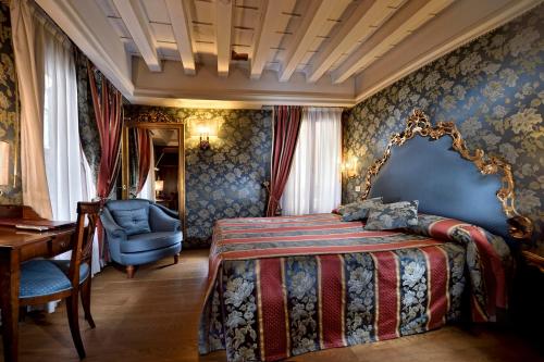 um quarto com uma cama, uma cadeira e uma secretária em Suites Torre Dell'Orologio em Veneza